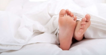 Piedi nudi di un bambino sdraiato, a illustrare la masturbazione infantile