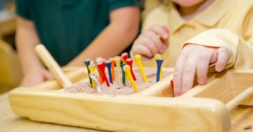 Bambino gioca con materiali sensoriali Montessori