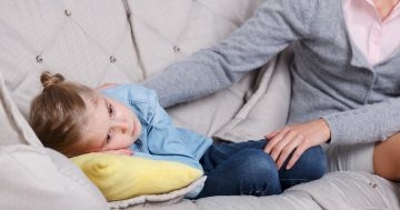 Bambina triste sdraiata sul divano