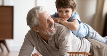 Nonno che gioca con un nipotino sulla schiena
