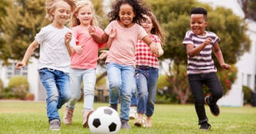 Bambine e bambini giocano a calcio