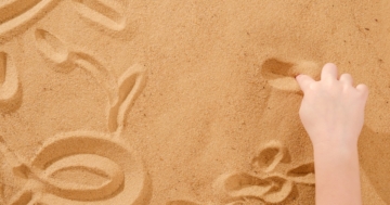 Mano di un bambino che gioca con la sabbia