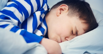 bambino al letto sofferente per dolori della crescita